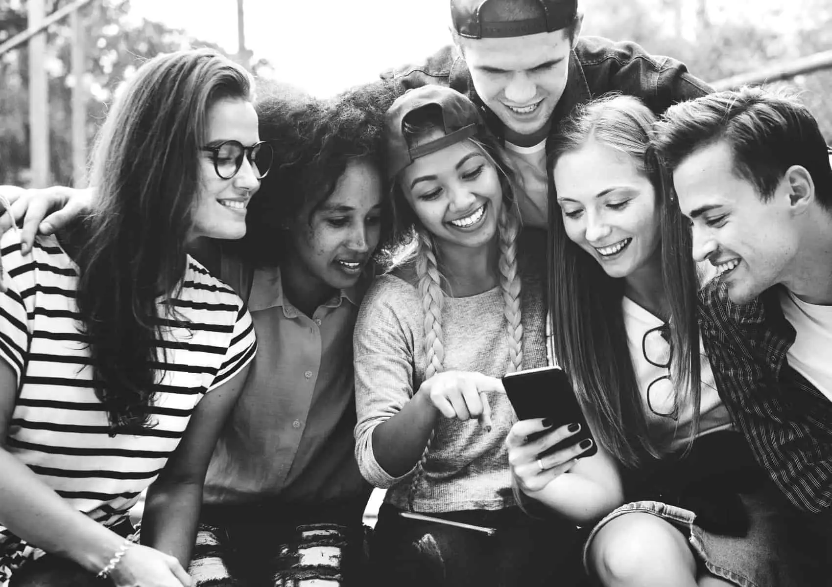 Friends in the park looking using smartphones millennial and you